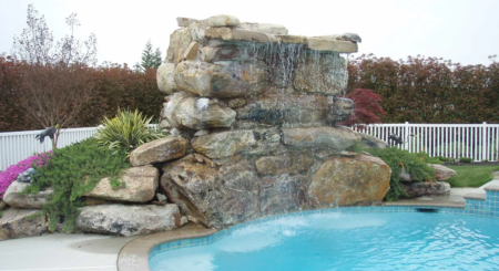 Natural stone waterfall and pond feature by Evergreen Hardscaping