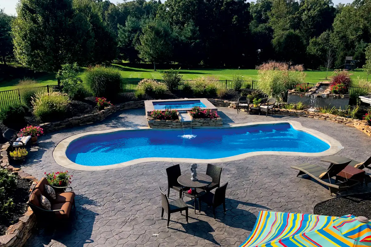 Fiberglass in-ground swimming pool installation by Evergreen Hardscaping